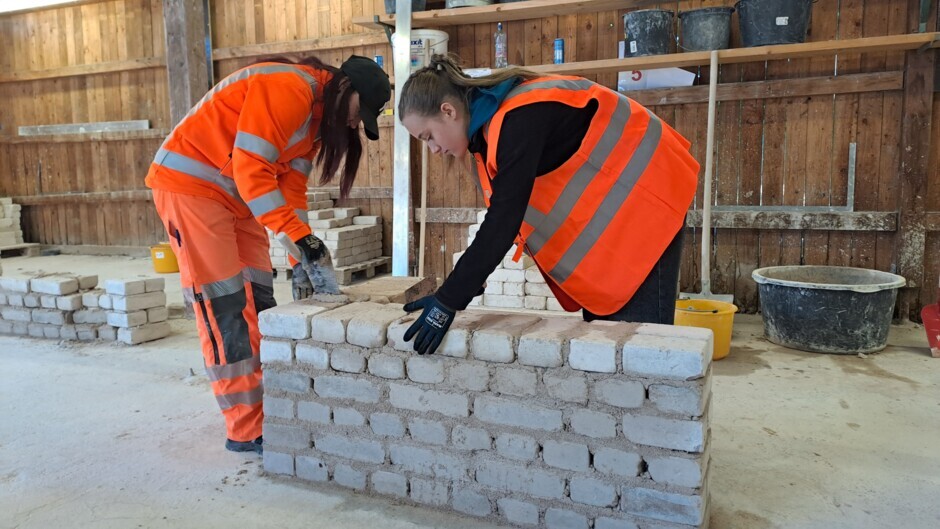 Beim Mauern arbeiten Schülerinnen und Auszubildende Seite an Seite.